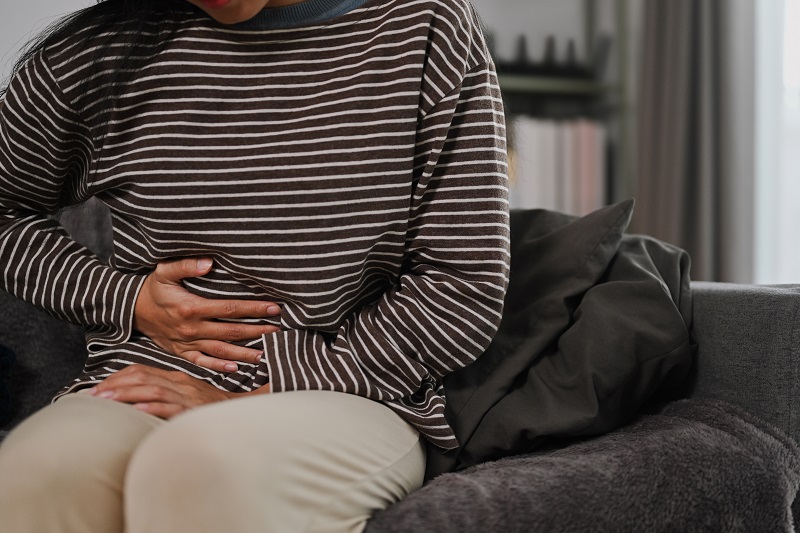 Woman clutching her stomach in discomfort.