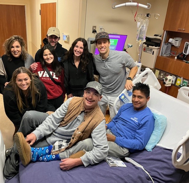 Evan in the hospital supported by a group of his friends.