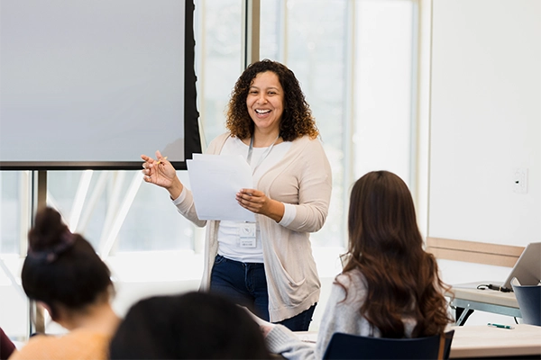 A woman gives a presentation in front of a group of work colleagues