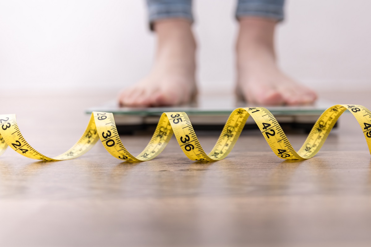 Feet on a scale with measuring tape